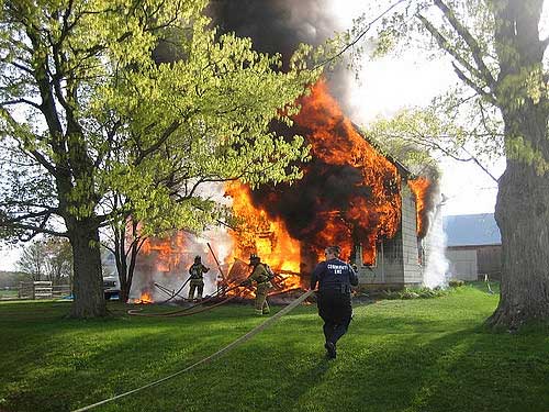 A burning house and fire fighter