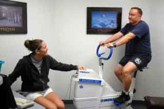 in this picture a lady and a men checking strength of exercise on machine 