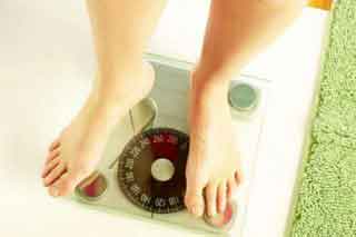 a women weighing her weight on scale